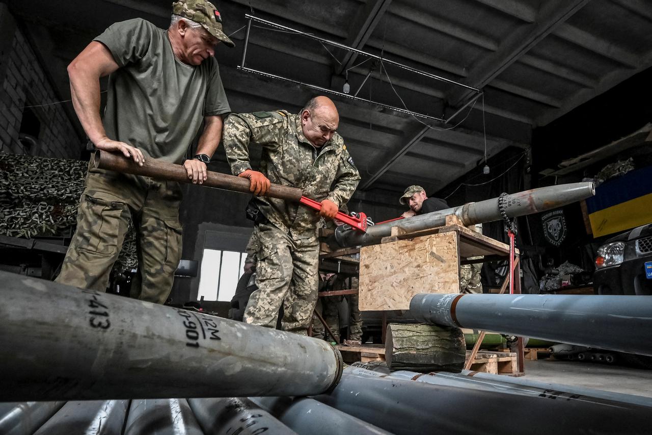 Members of company tactical group "Steppe Wolves" disassemble a shell for a BM-21 Grad multiple launch rocket system to convert it for use with a handmade small MLRS for firing toward Russian troops in Zaporizhzhia region